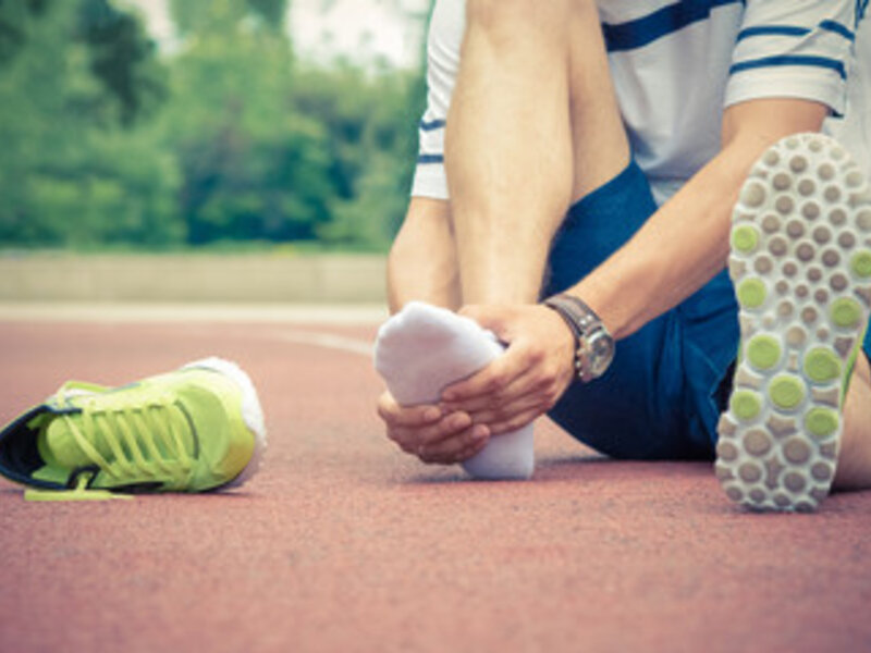 Patient with plantar fasciitis holding custom Sole Supports orthotic insert at Absolute Wellness Peoria IL